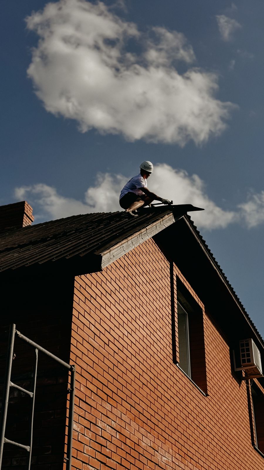 A worker carrying out repairs on a residential roof